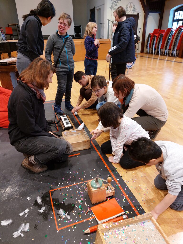 Schüler hocken auf dem Boden und untersuchen Gegenstände.
