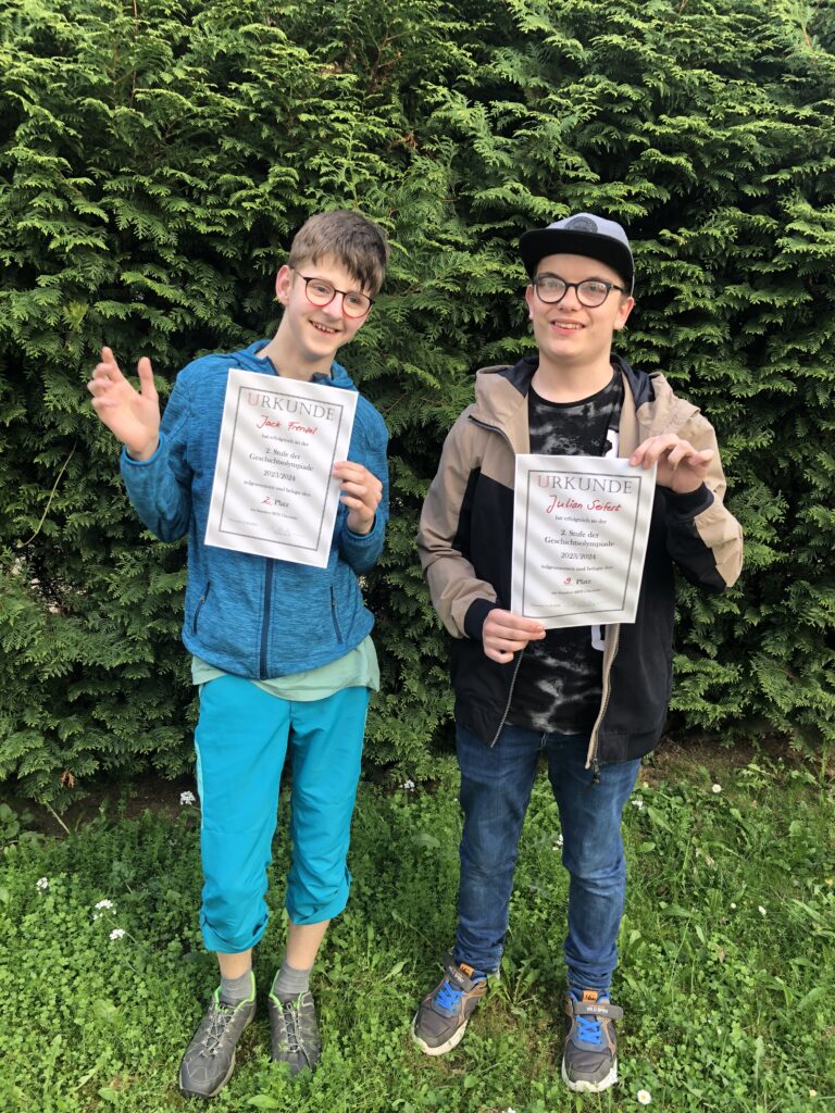 Zwei Schüler zeigen ihre Urkunden