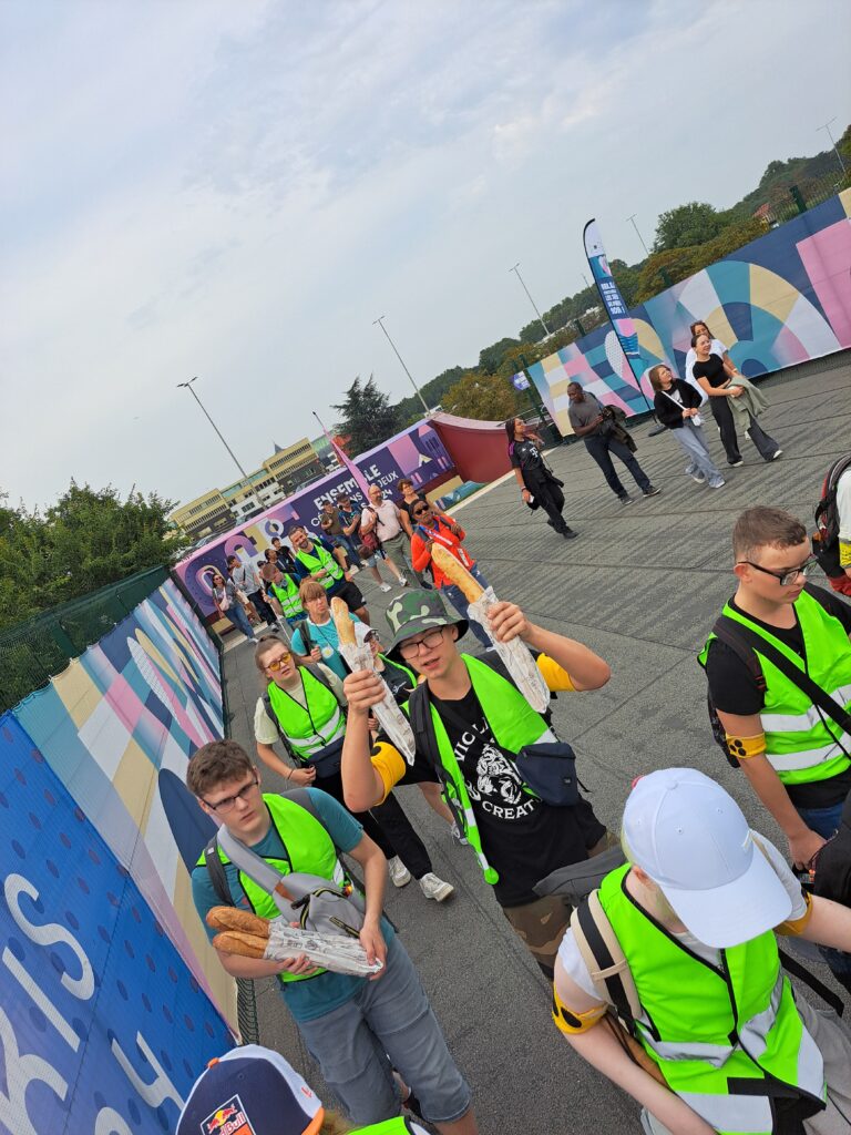 Die Reisegruppe ist auf dem Weg ins Stade de France. Ein Schüler hält zwei Baguettes nach oben.